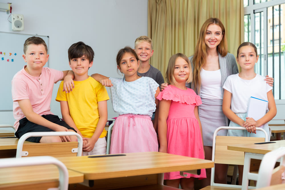 Group portrait of positive school children with teacher