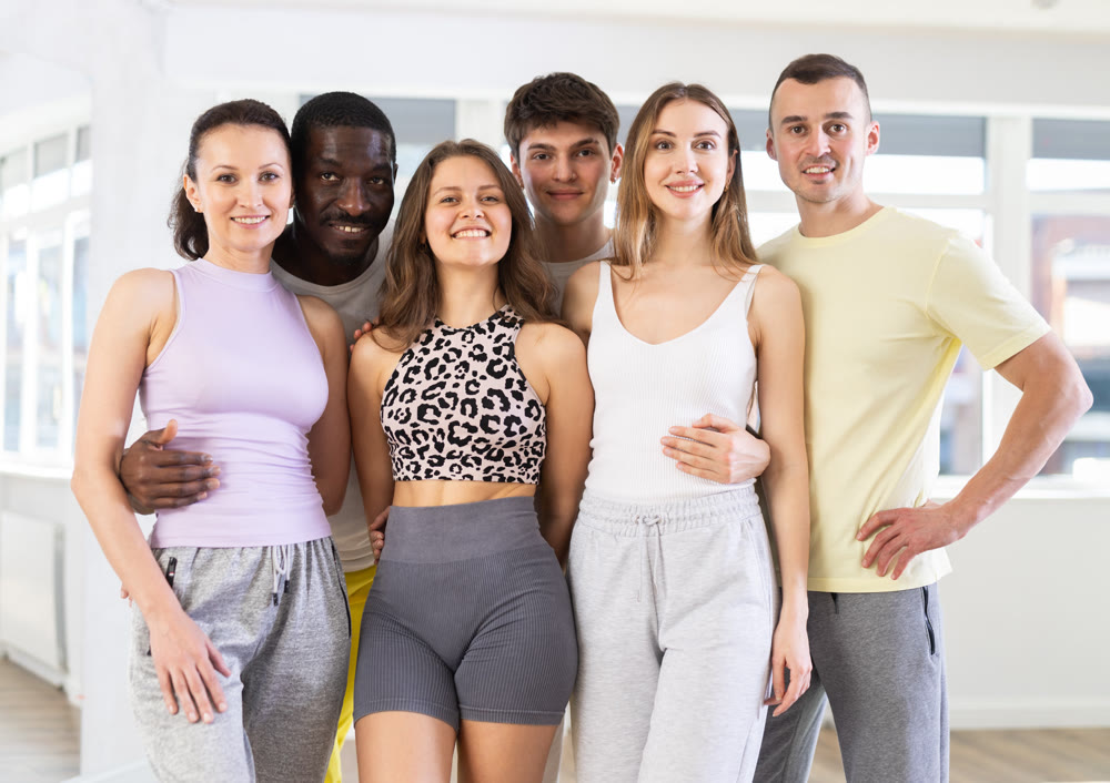 Group of men and woman posing in dance studio