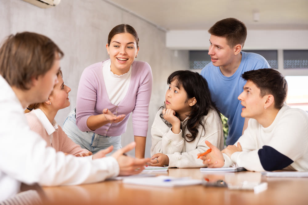 Group of students preparing for exam together in classroom of college