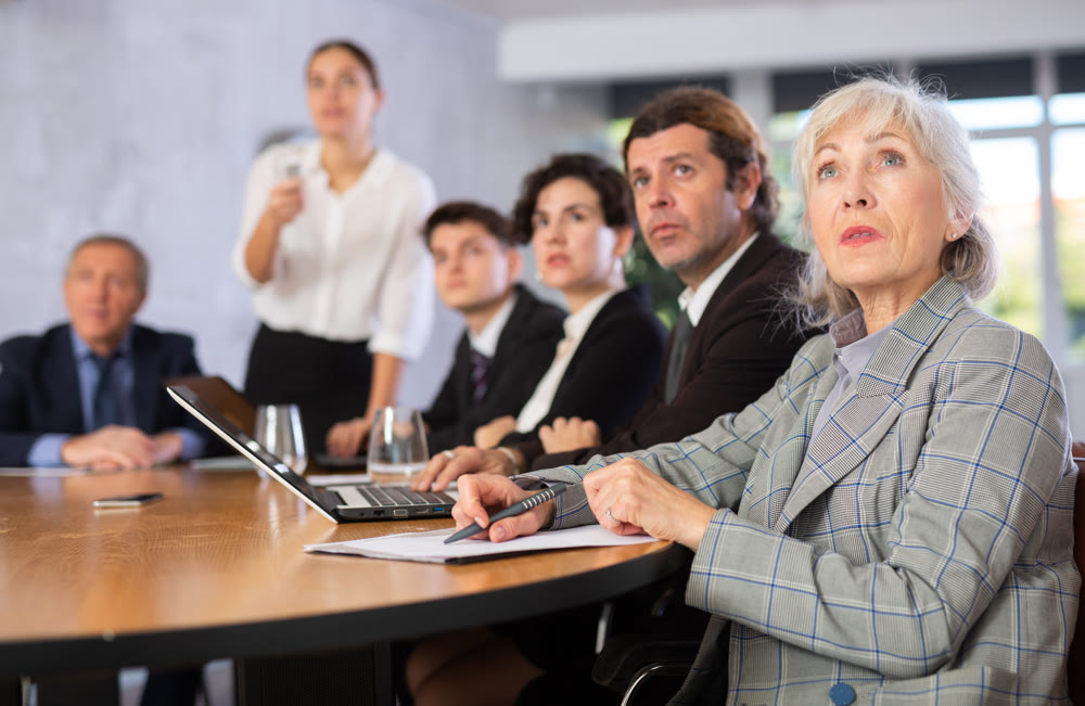 Group of businessmen attentively watching a presentation in meeting room