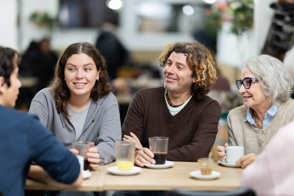 Large friendly family gathered at table to have meeting in restaurant