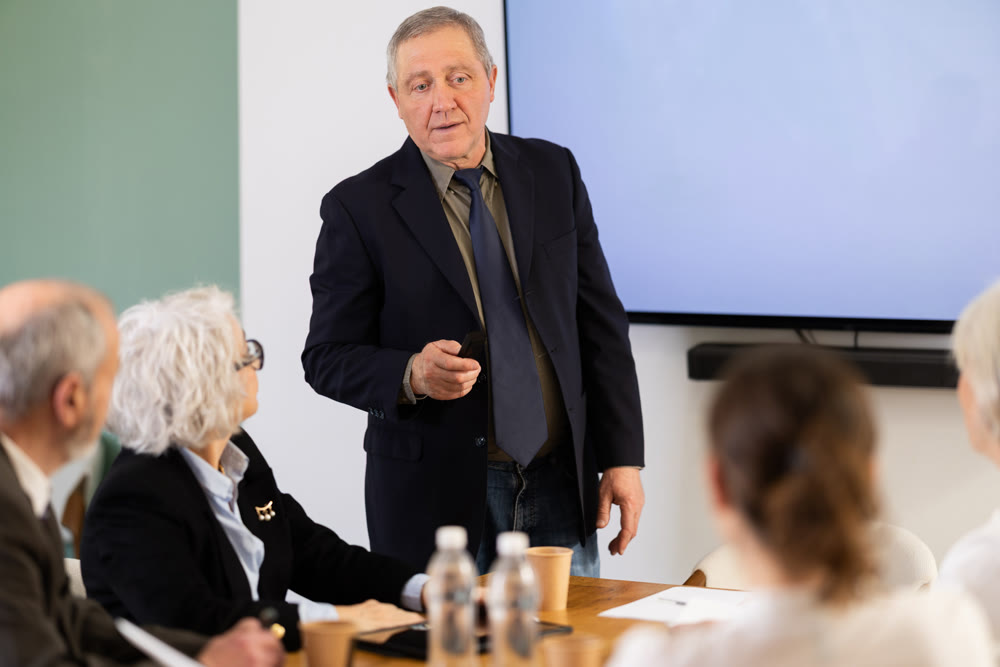 Elderly man presenting with remote control
