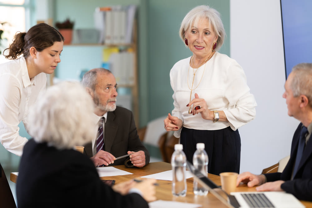 Female leader, trainer talking to group of people, brainstorming, discussing ideas in auditory