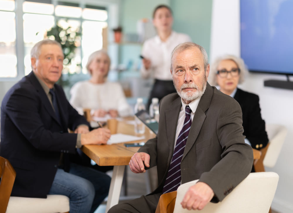 Girl with remote controller tell material, speaks to mature precursors of business group