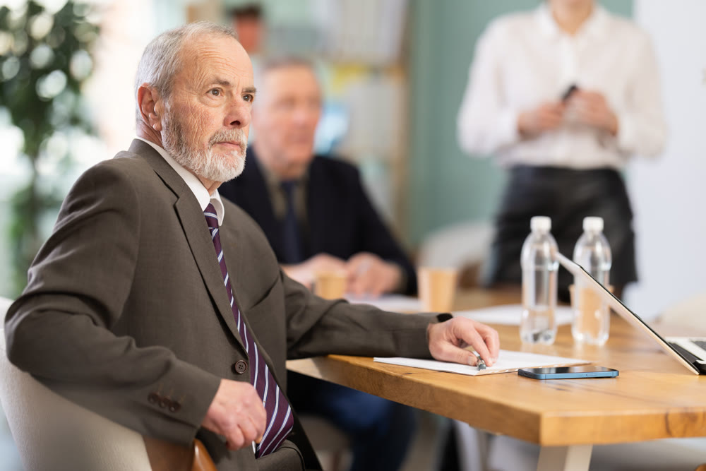 Girl with remote controller tell material, speaks to mature precursors of business group