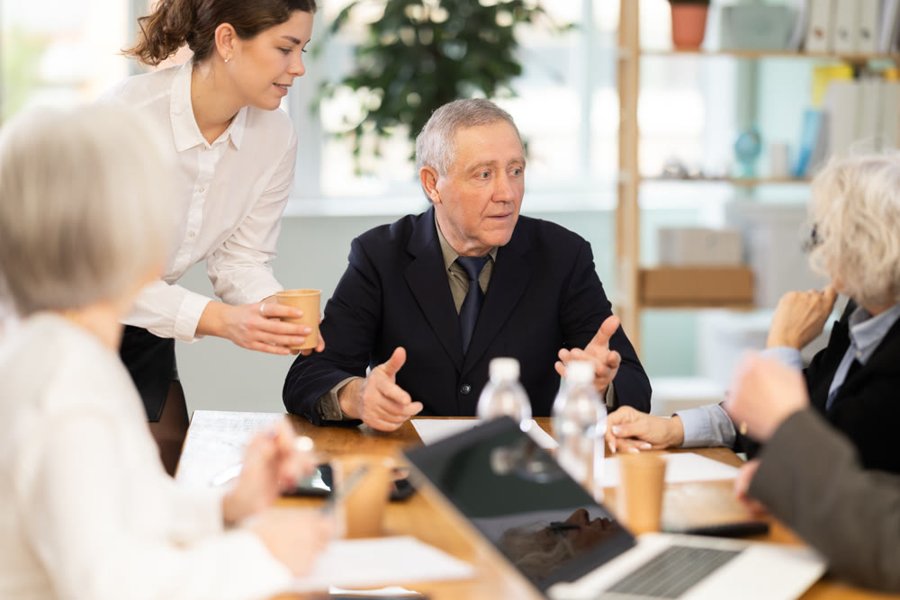 Male leader, trainer talking to group of people, brainstorming, discussing ideas in auditory