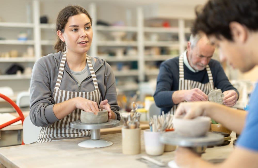 Young woman and man and elderly man crafting ceramics