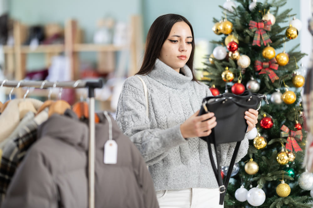 Young girl choosing handbag in clothing store