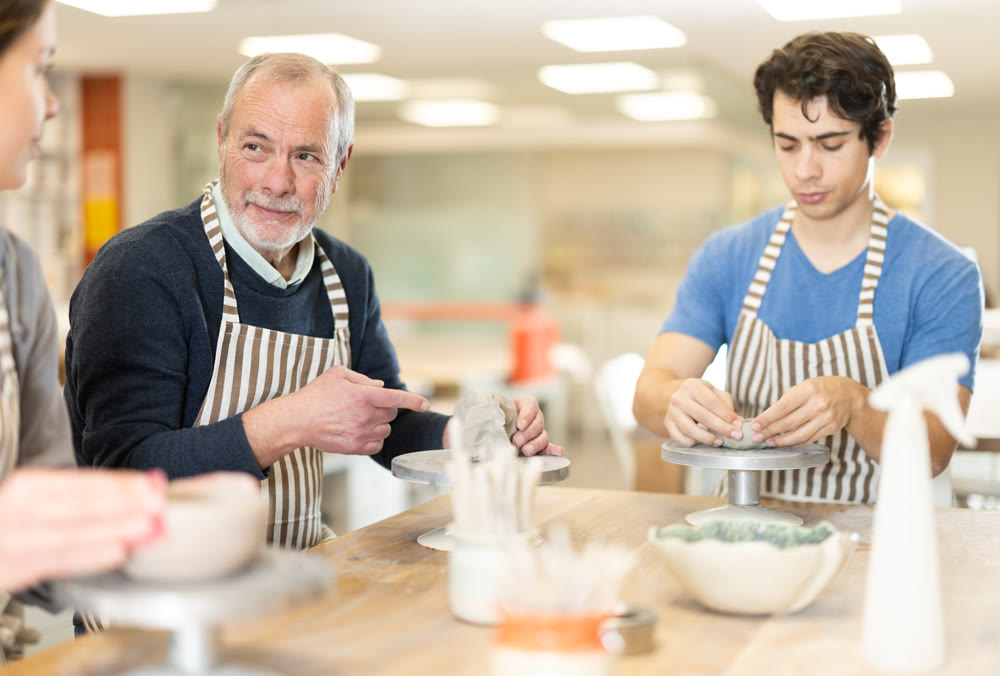 Young woman and man and elderly man crafting ceramics