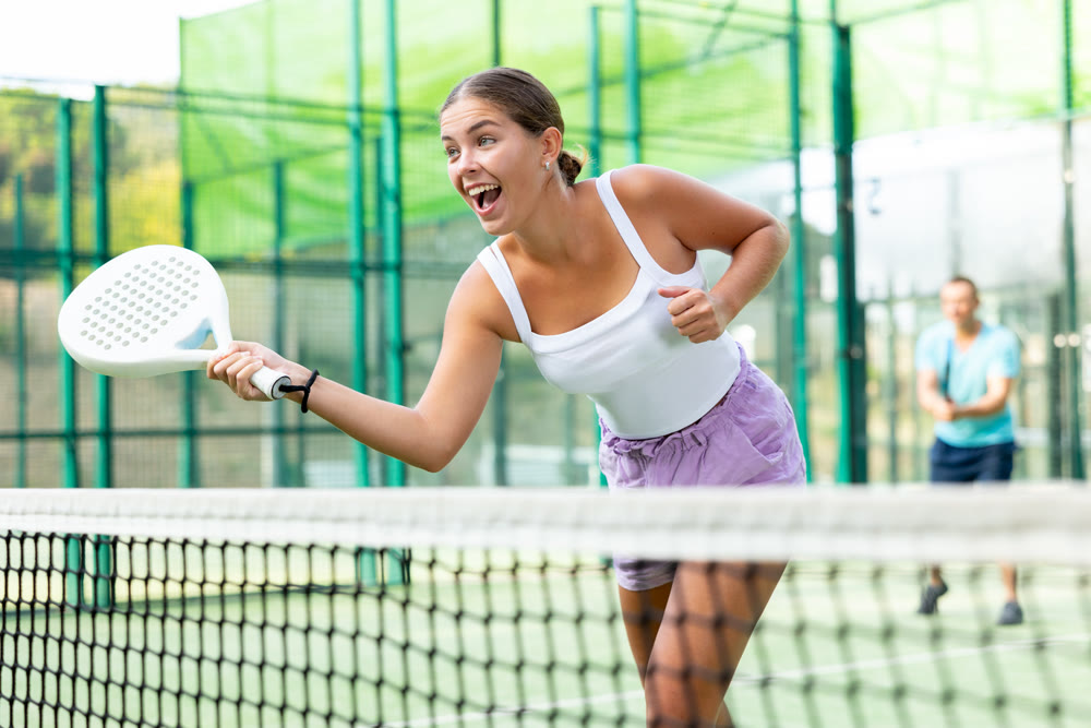 Girl playing padel tennis match during training on court