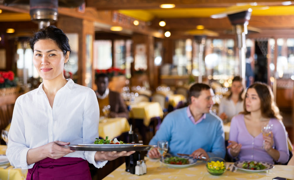 Portrait of asian waitress standing in restaurant