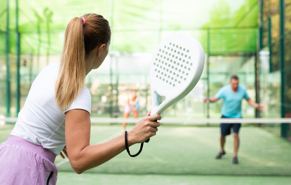 Woman playing padel tennis match during training on court