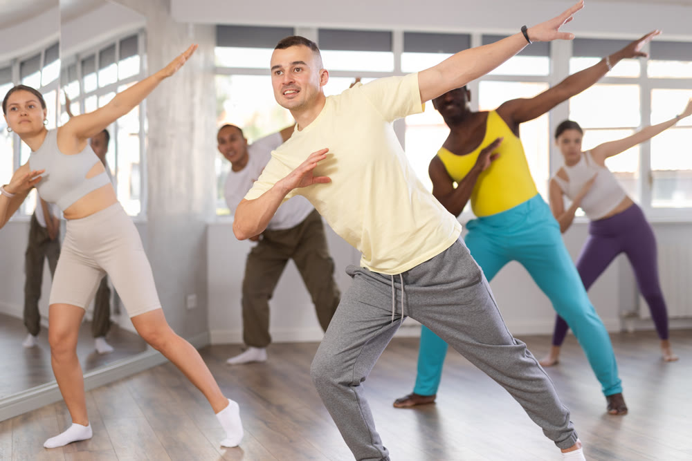 Young dancer rehearsing popping techniques during group workout