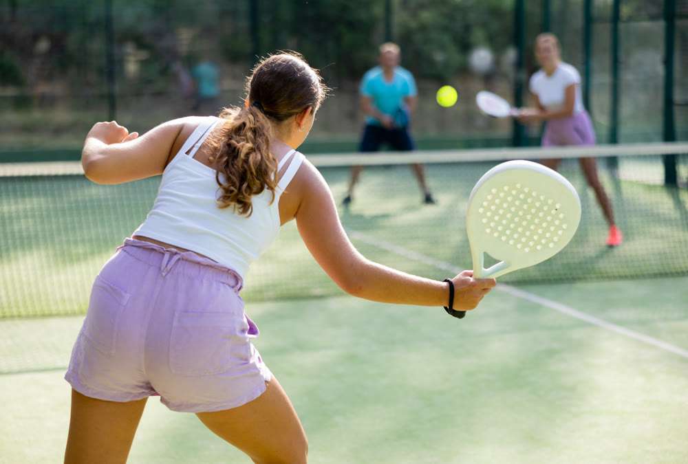 Woman playing padel tennis match during training on court