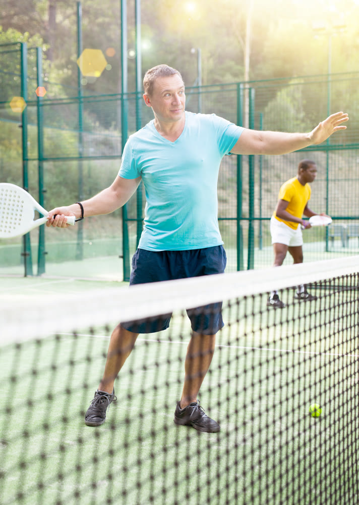 Man playing padel tennis on court