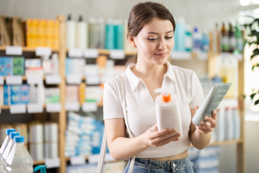 Young woman choosing a cream in a pharmacy