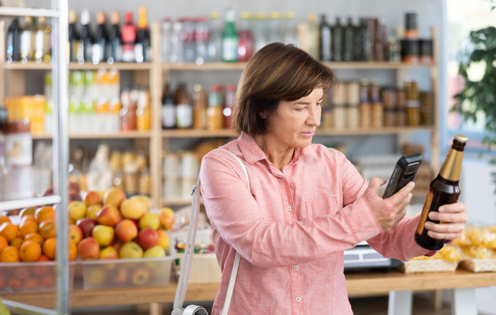 Female buyer scans QR code on beer label in grocery store