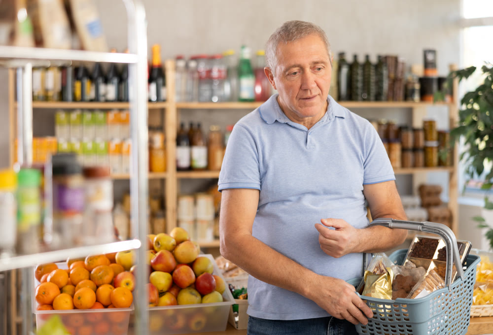 Mature man choosing something in grocery store