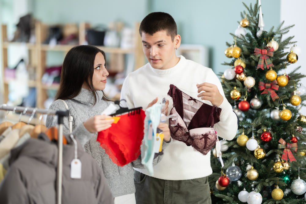 Couple chooses lingerie for girl in a clothing store during Christmas celebrations.