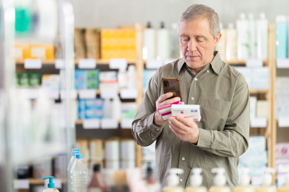 Senior man buys paracetamol pills at pharmacy