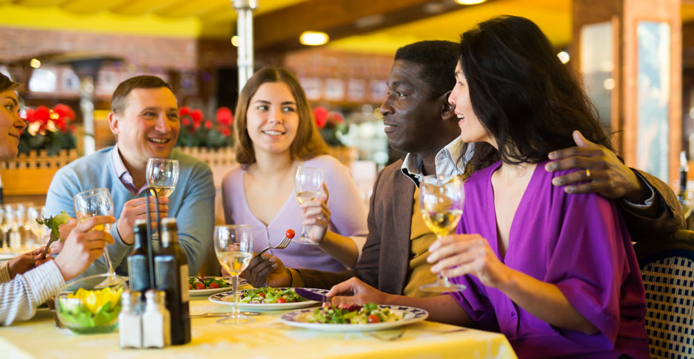 Happy adult people having fun in restaurant during dinner