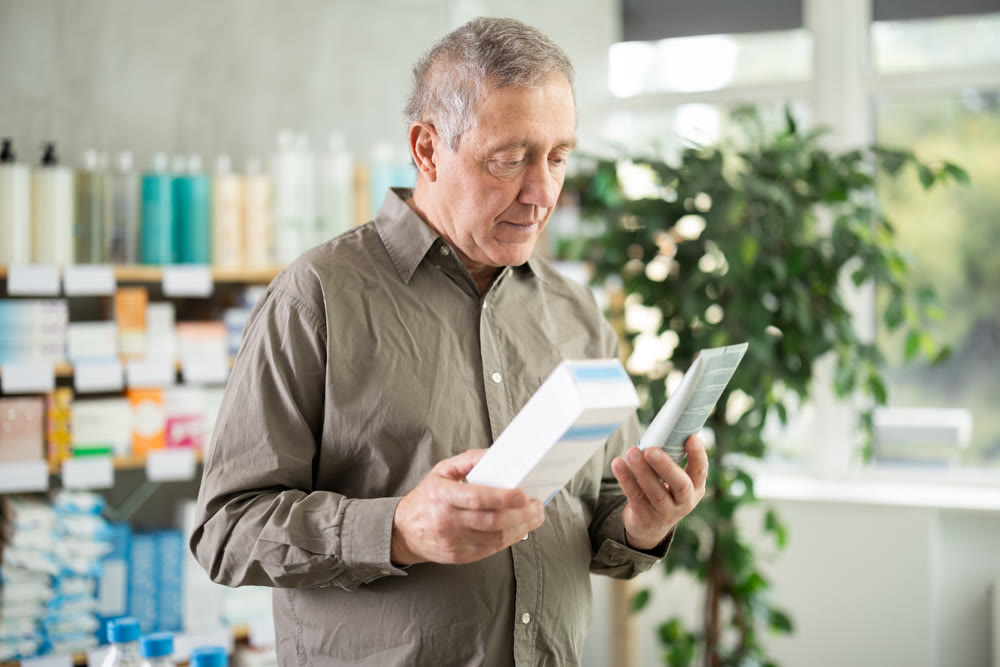Elderly man choosing a cream at the pharmacy