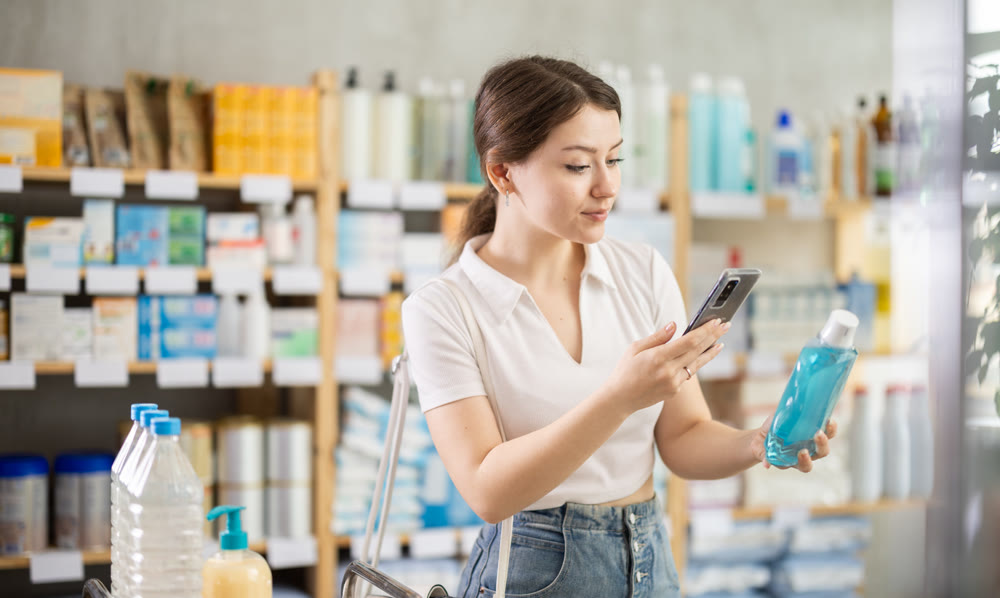 Young woman scanning qr code of mouthwash
