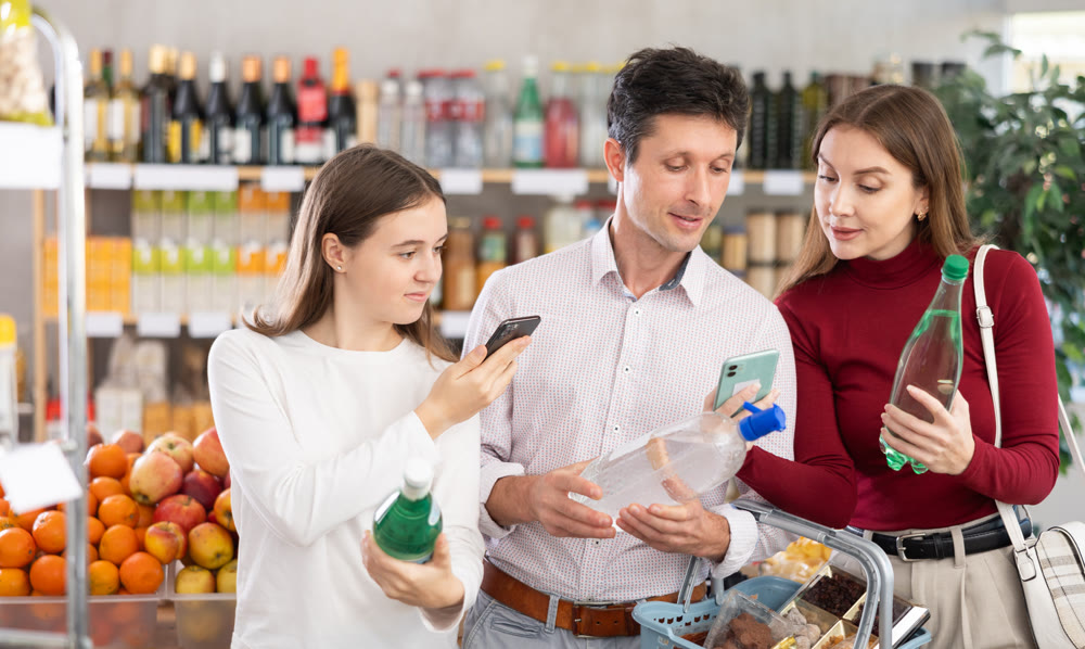 Family of buyers scans QR code on soda water packaging