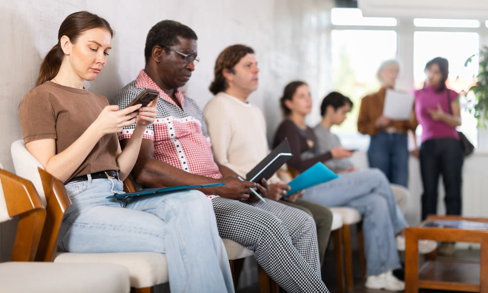 People sitting in line inside a modern office