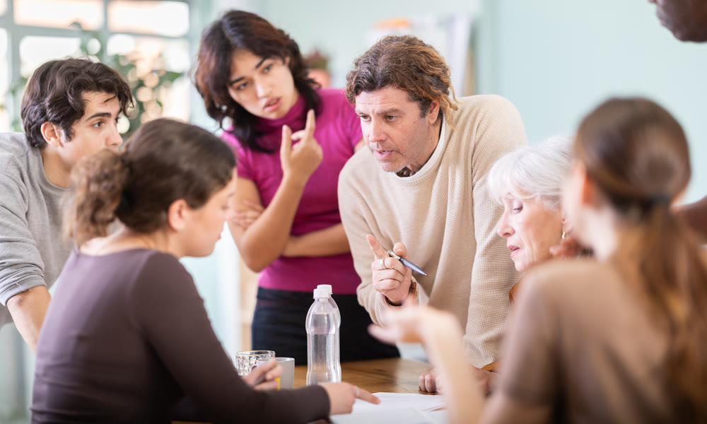 Men and women of different ages actively communicating at table