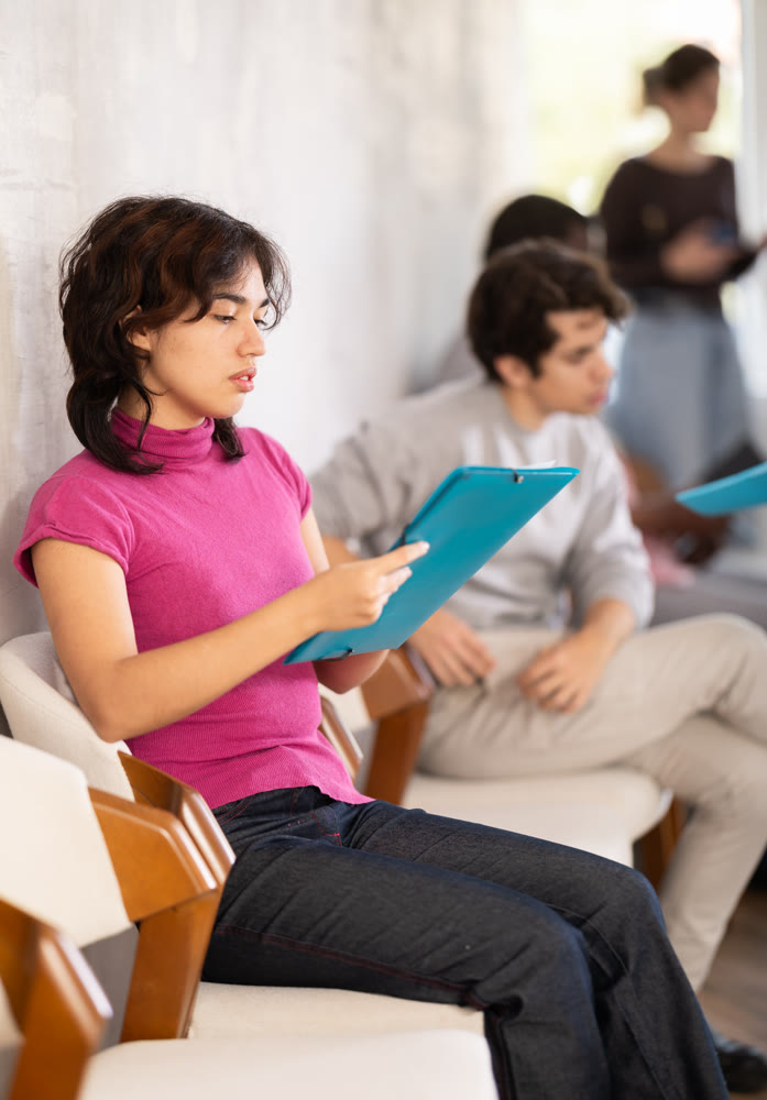 Young girl applicant sitting in a queue at a modern office