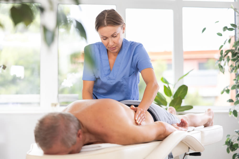masseuse giving massage to male patient