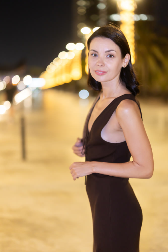 Woman walking along coastal promenade at night in Barcelona