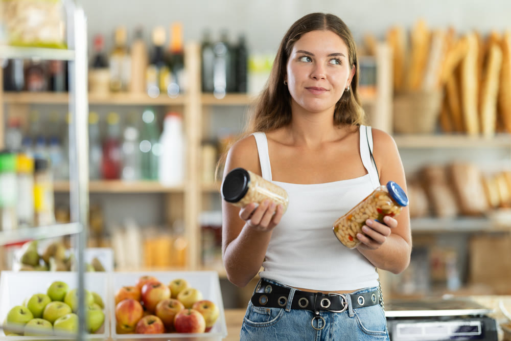 Young woman choosing beans in grocery store