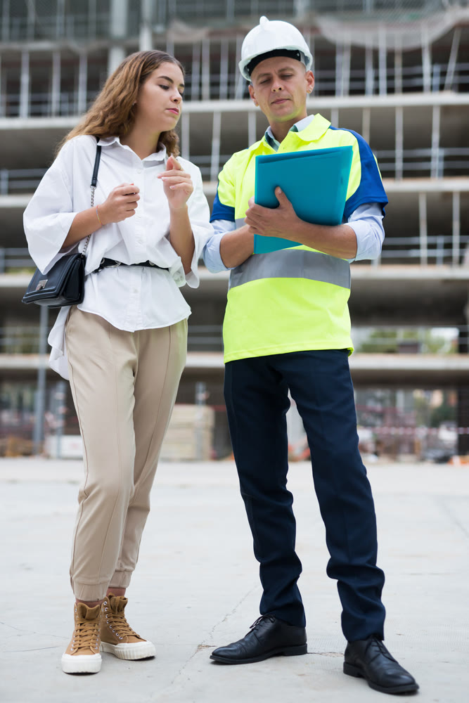 Builder talking with client at construction site