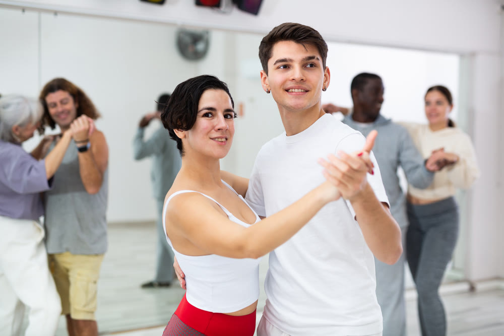 Caucasian man and lady rehearsing latin paired dance moves