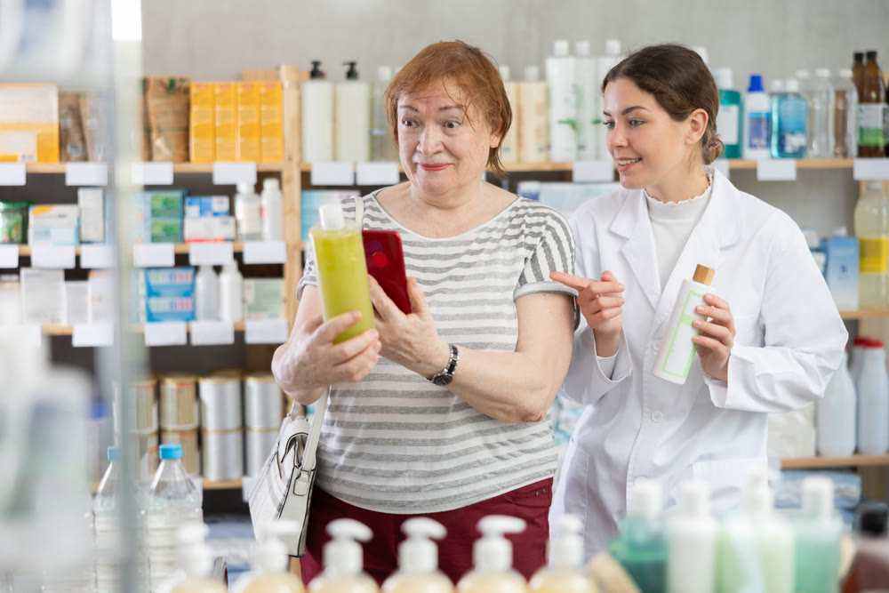 Woman buyer scans shampoo or shower gel qr code with pharmacist