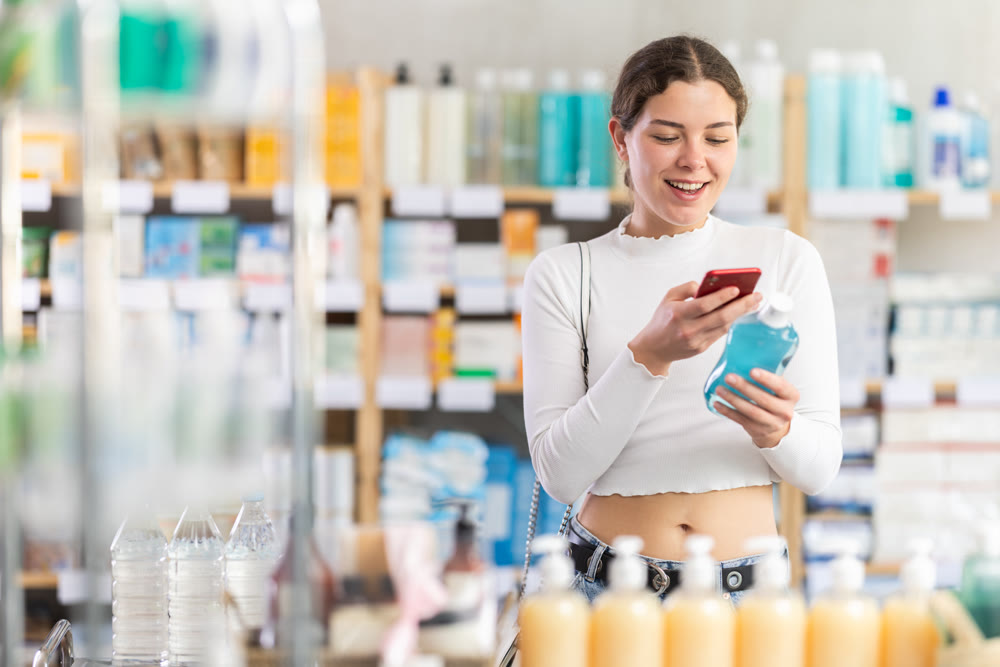 woman scans a plastic bottle with rinse aid on her mobile