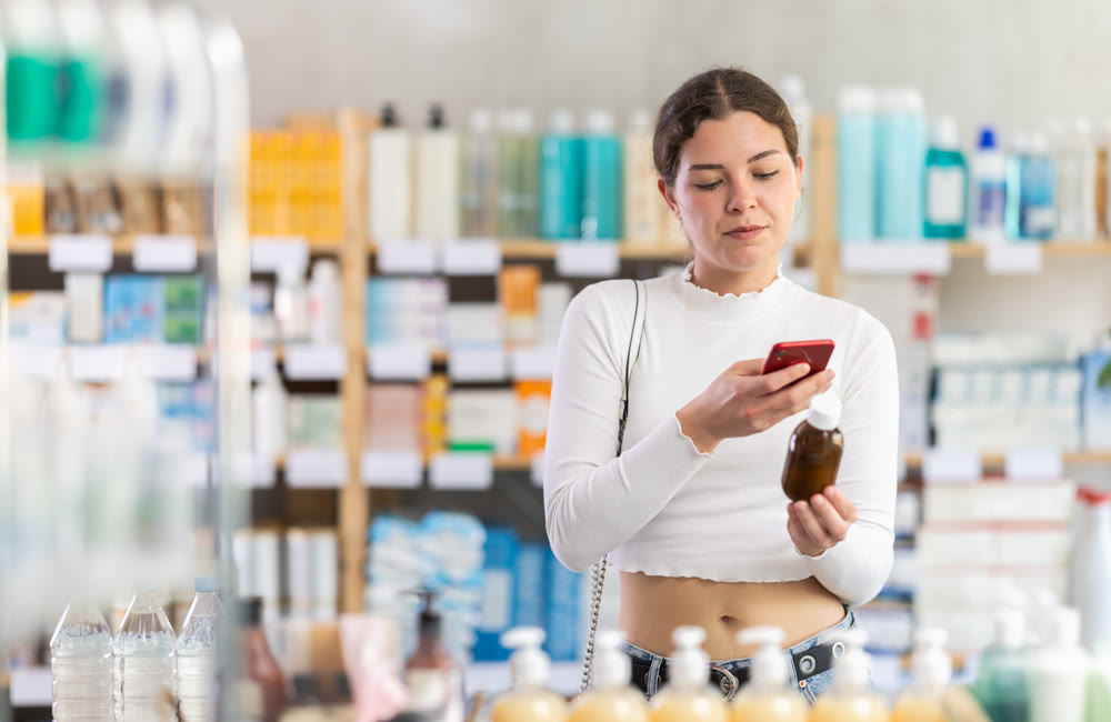 Female buyer scans code on cough syrup to check expiration date