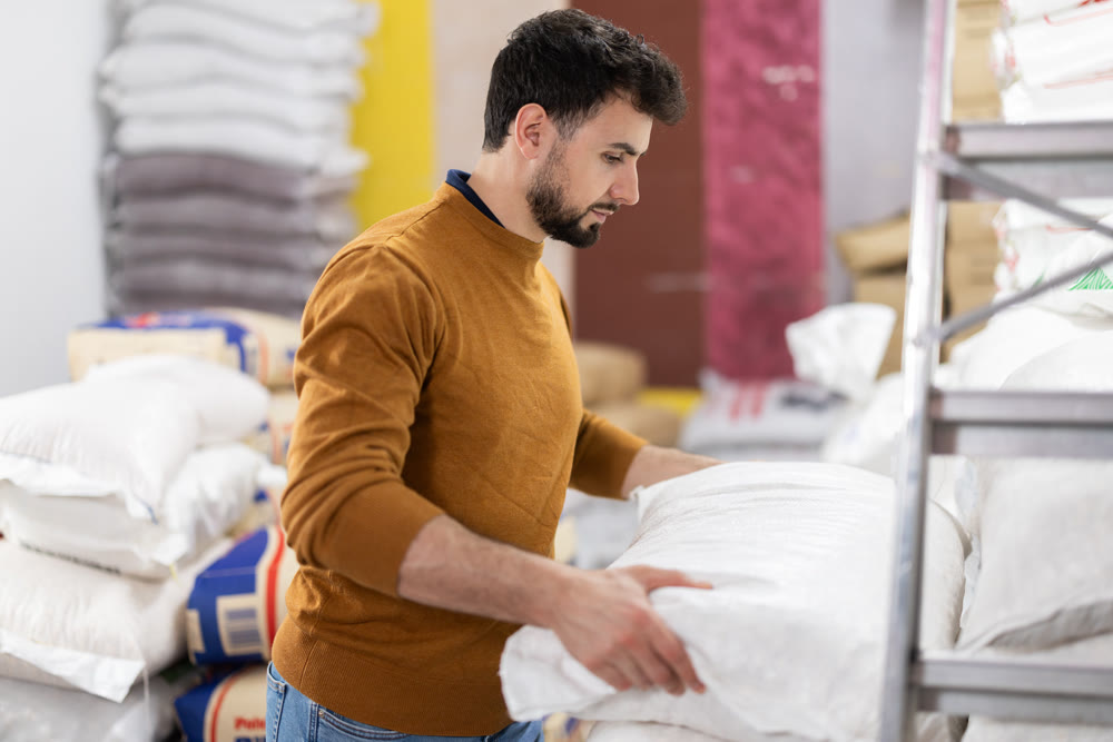 Young man puts bag in grocery warehouse