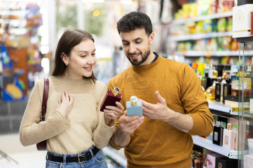 Couple choosing bottle of perfume in perfume shop