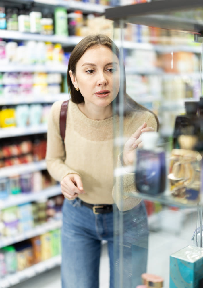 Young woman chooses perfume in store