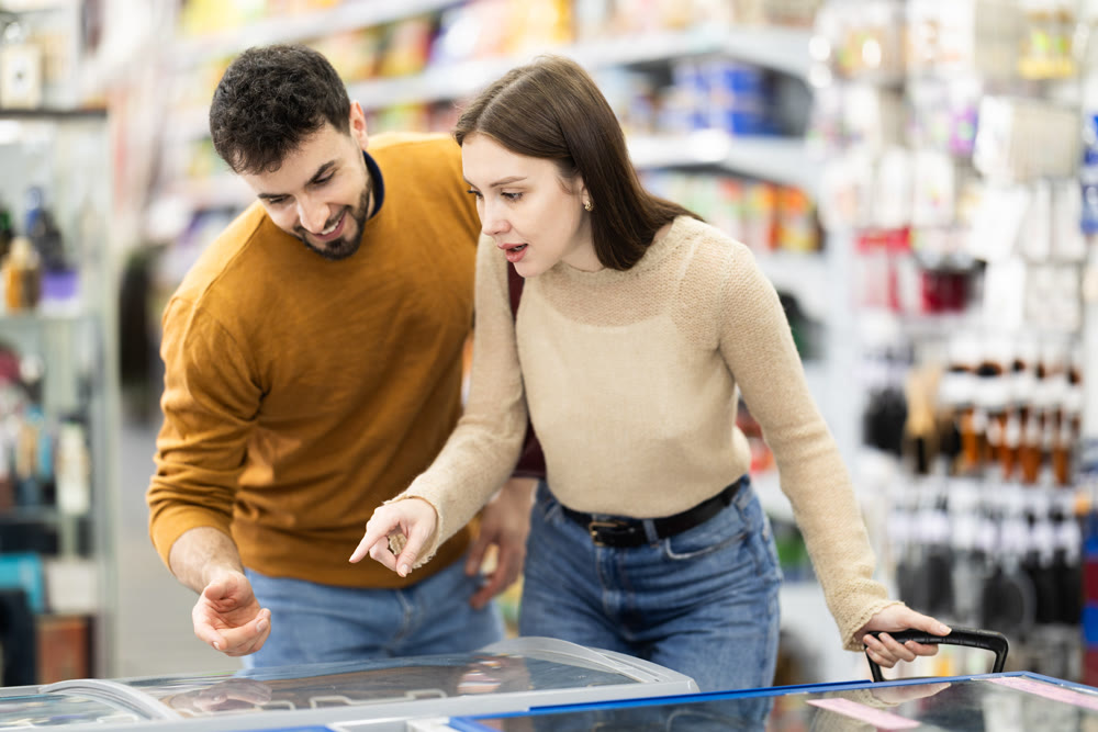 Young couple choosing frozen food in grocery store