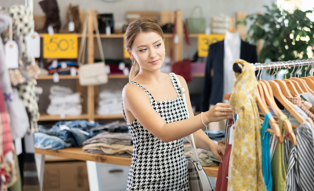 Female shopper looking for summer clothing in outlet store