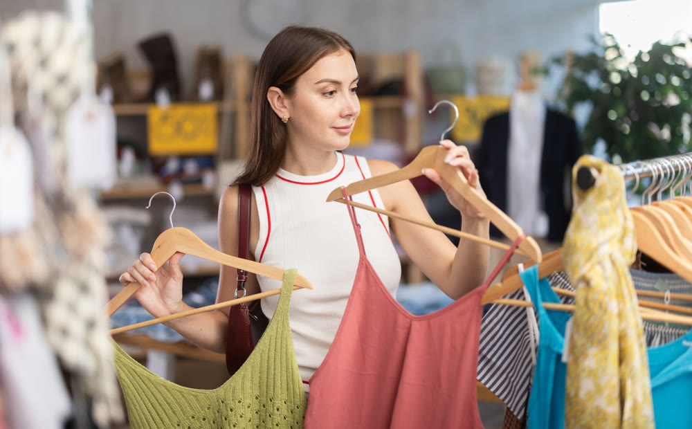 Young woman browsing summer dresses in local store