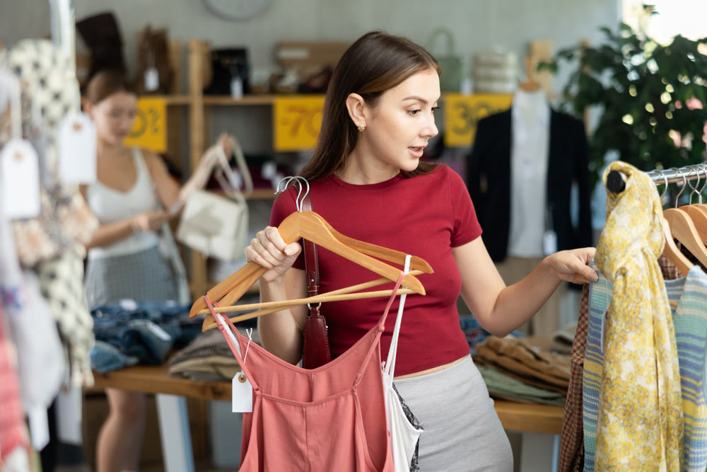 Young woman browsing summer dresses in local store