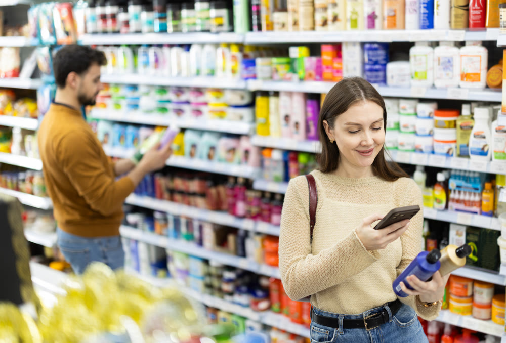 Woman get acquainted with good, scan QR code, take reading label using phone camera in shop