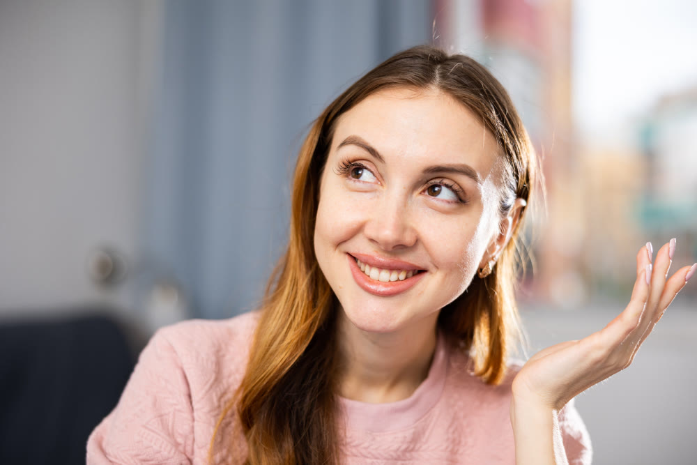 Close-up portrait of a positive girl at the table in room
