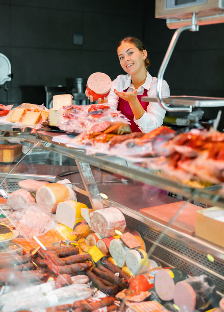 Young woman butchery worker at counter
