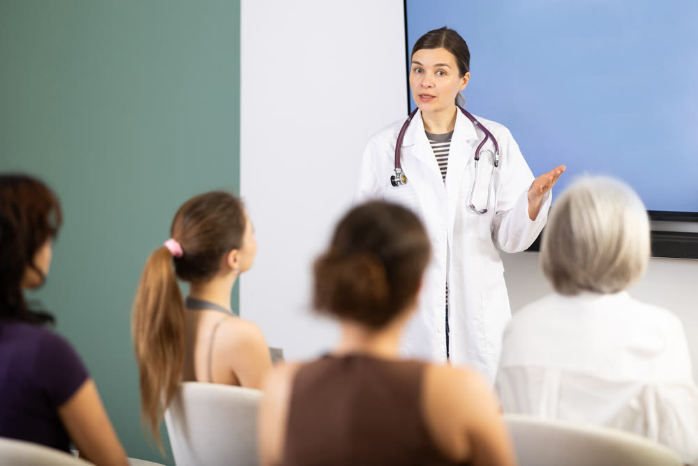 Middle-aged medical professor explaining presentation to female audience
